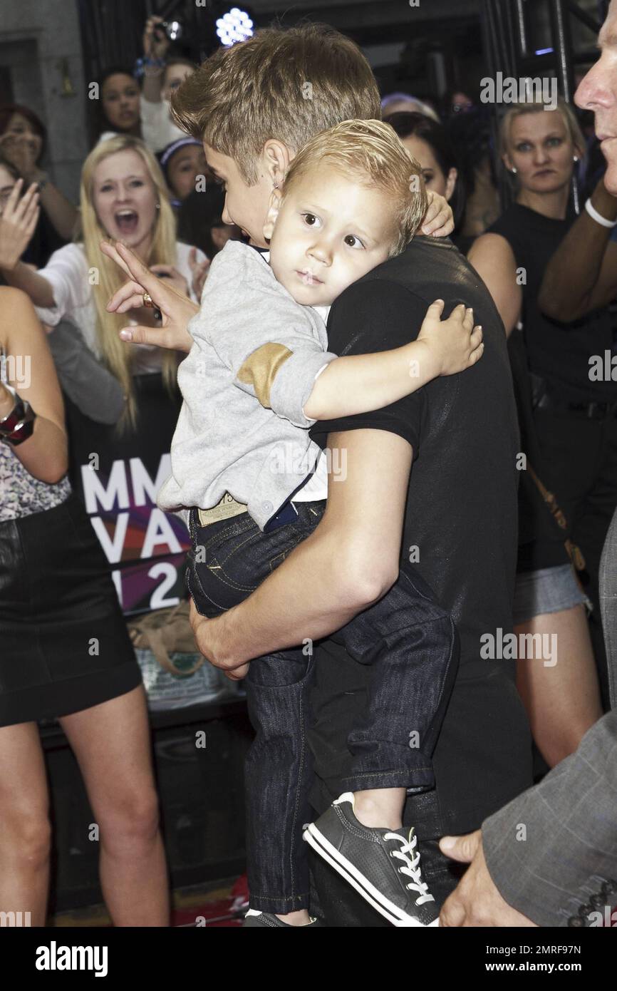 Justin Bieber carries baby brother Jaxon at the 23rd Annual MuchMusic