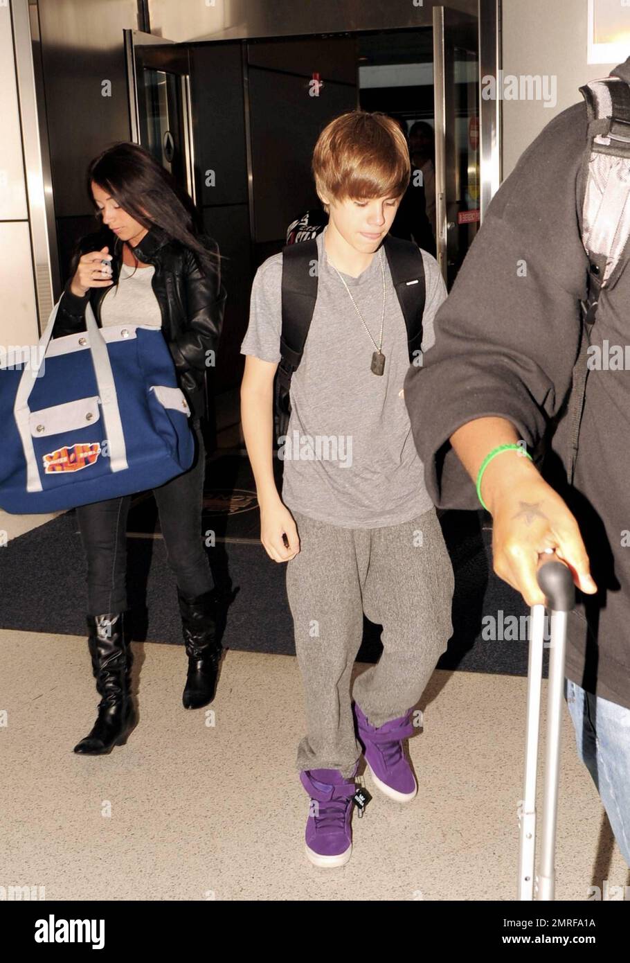 EXCLUSIVE!! Canadian teen pop star Justin Bieber dons some colorful purple  high-top sneakers for his flight out of Miami International Airport after  attending Super Bowl festivities in Miami, FL. 2/8/10 Stock Photo -