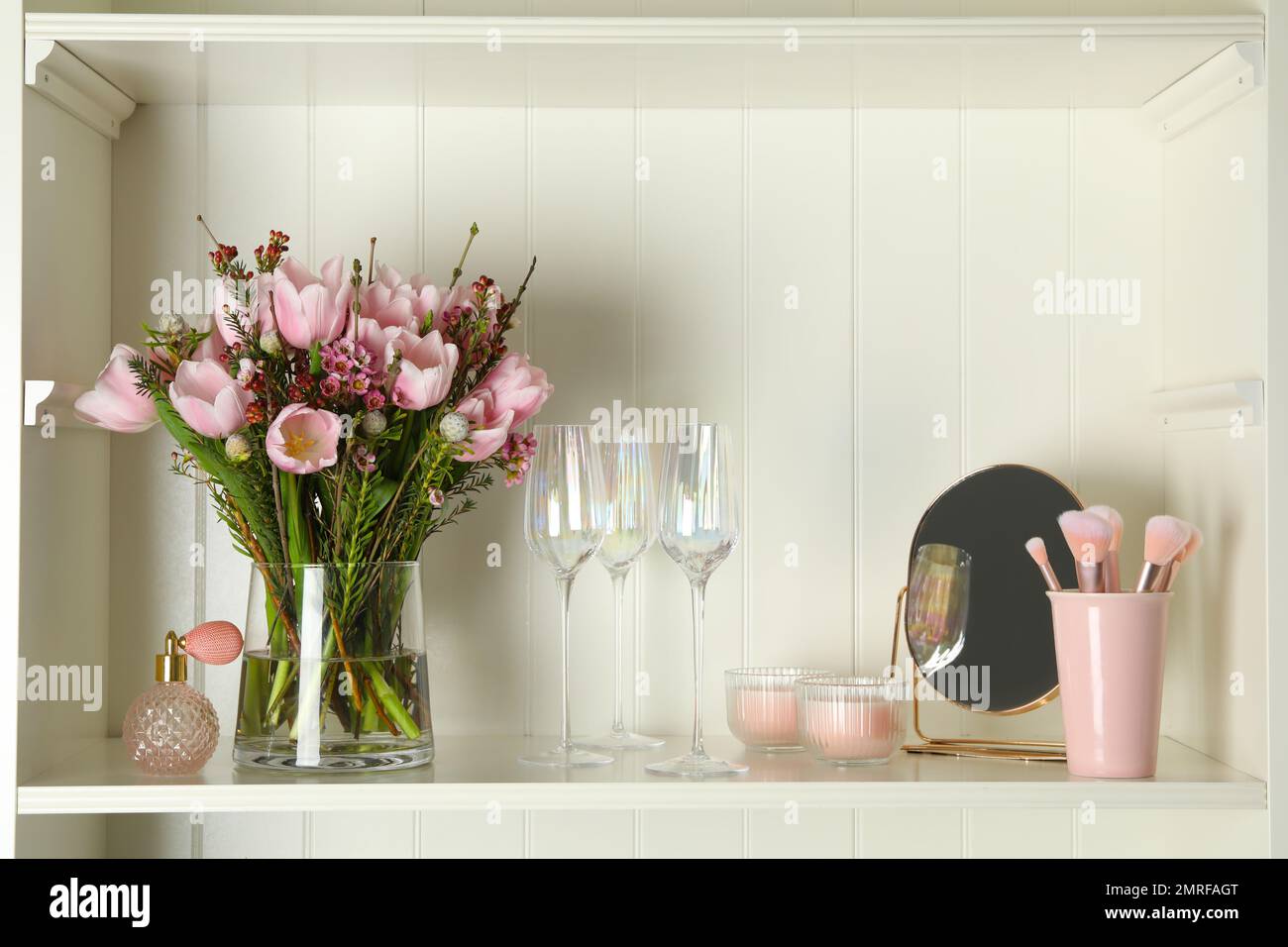 White shelving unit with glassware and different decorative elements