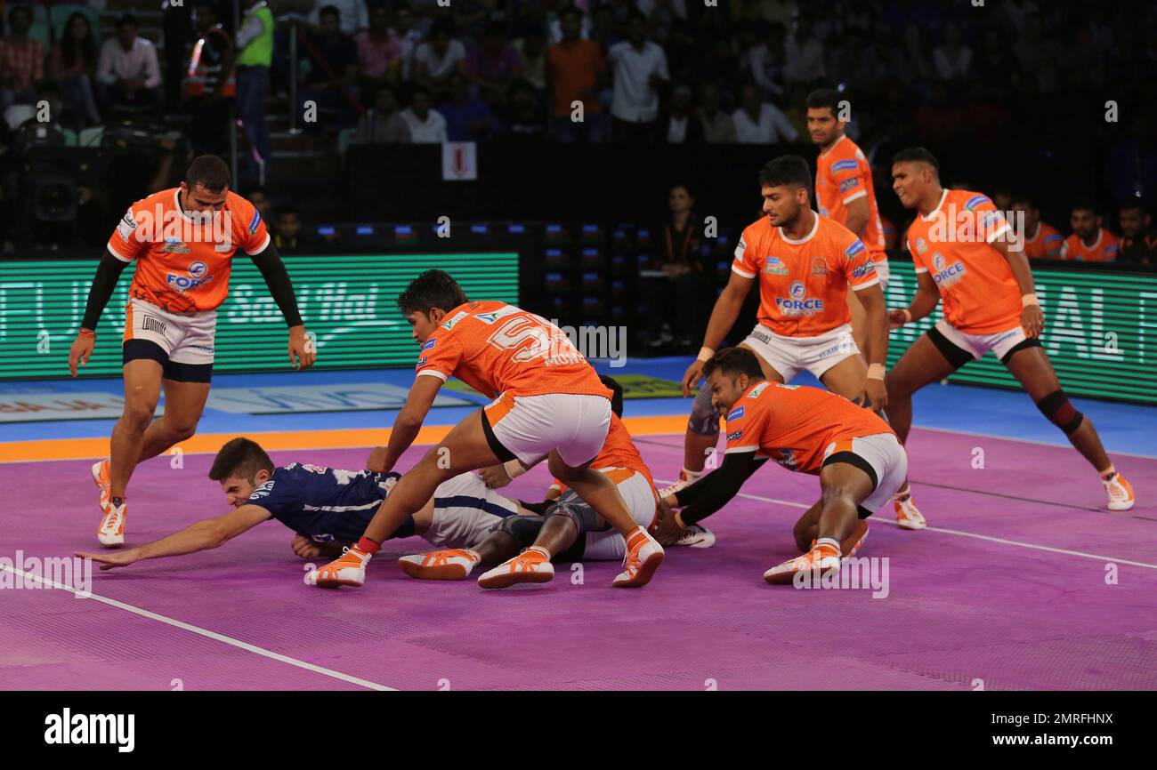 Players of Puneri Paltan pin down Monu Goyat, in green jersey, of Patna  Pirates during their Vivo Pro Kabaddi league match in Mumbai, India,  Tuesday, Oct. 24, 2017. (AP Photo/Rafiq Maqbool Stock