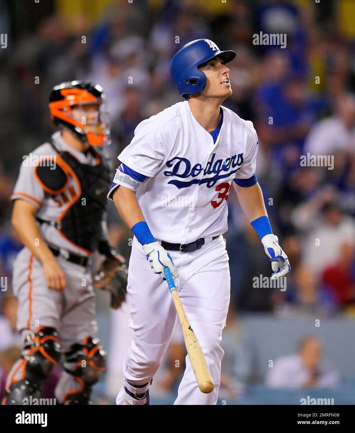Los Angeles Dodgers' Cody Bellinger, right, runs to first after hitting