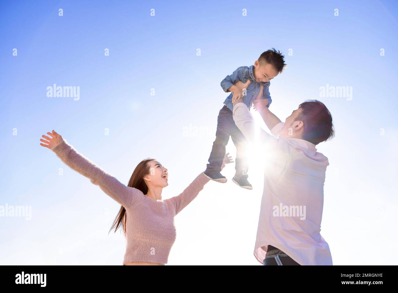 Happy Asian family  standing and playing with son Stock Photo
