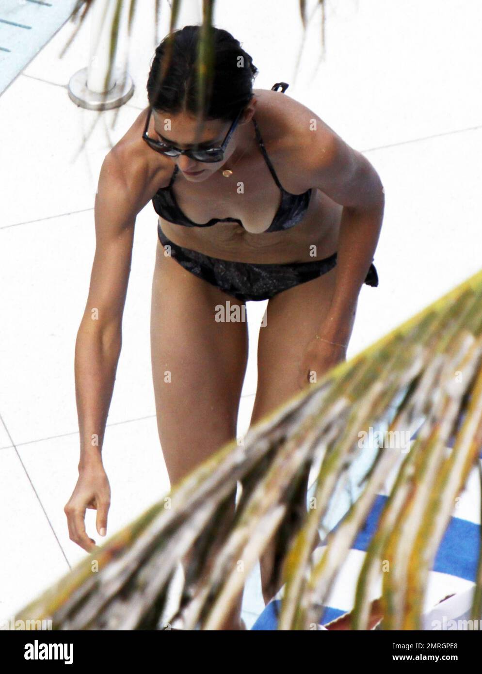 Katie Holmes shows off her slender figure in a black bikini as she relaxes  poolside in Miami, FL. 7/17/11 Stock Photo - Alamy