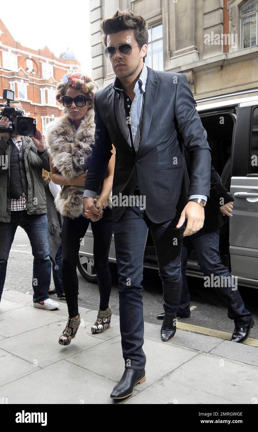 Katie Price and new boyfriend, model Leandro Penna, leave BBC Radio 2. With her hair in curlers, Katie (aka Jordan) wore a fur vest, black leggings and some funky skull-patterned high heels as the two left the building hand-in-hand. Katie, who recently split from husband Alex Reid after less than a year of marriage, has reportedly signed a $1.3 million deal to host a new reality series called 'Make Me a Hunk,' in which she will help to transform 'nerdy' men into hunks. London, UK. 3/22/11. Stock Photo