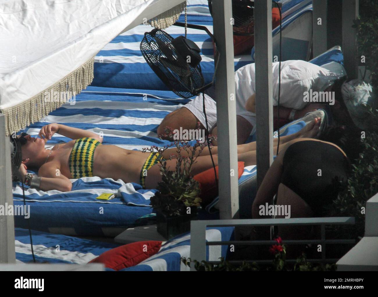 Katy Perry relaxes on a roof top pool in a tie dye bikini and sips on a ...