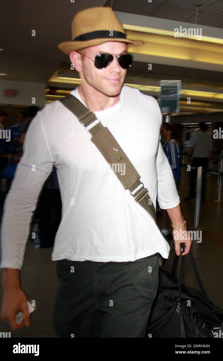 EXCLUSIVE!! Actor Kellan Lutz of the famed 'Twilight' films arrives at LAX to check in for a flight out of town. Lutz tries his best to stay incognito wearing a straw fedora and aviator sunglasses while standing with other passengers who were waiting to check in. The teen heartthrob and former Abercrombie & Fitch model also carried his own duffle bag.  Lutz, who is currently dating '90210' actress AnnaLynne McCord, is set star alongside young actresses Mandy Moore, Nina Dobrev and Isabel Lucas in his upcoming films. Los Angeles, CA. 05/30/10.    . Stock Photo