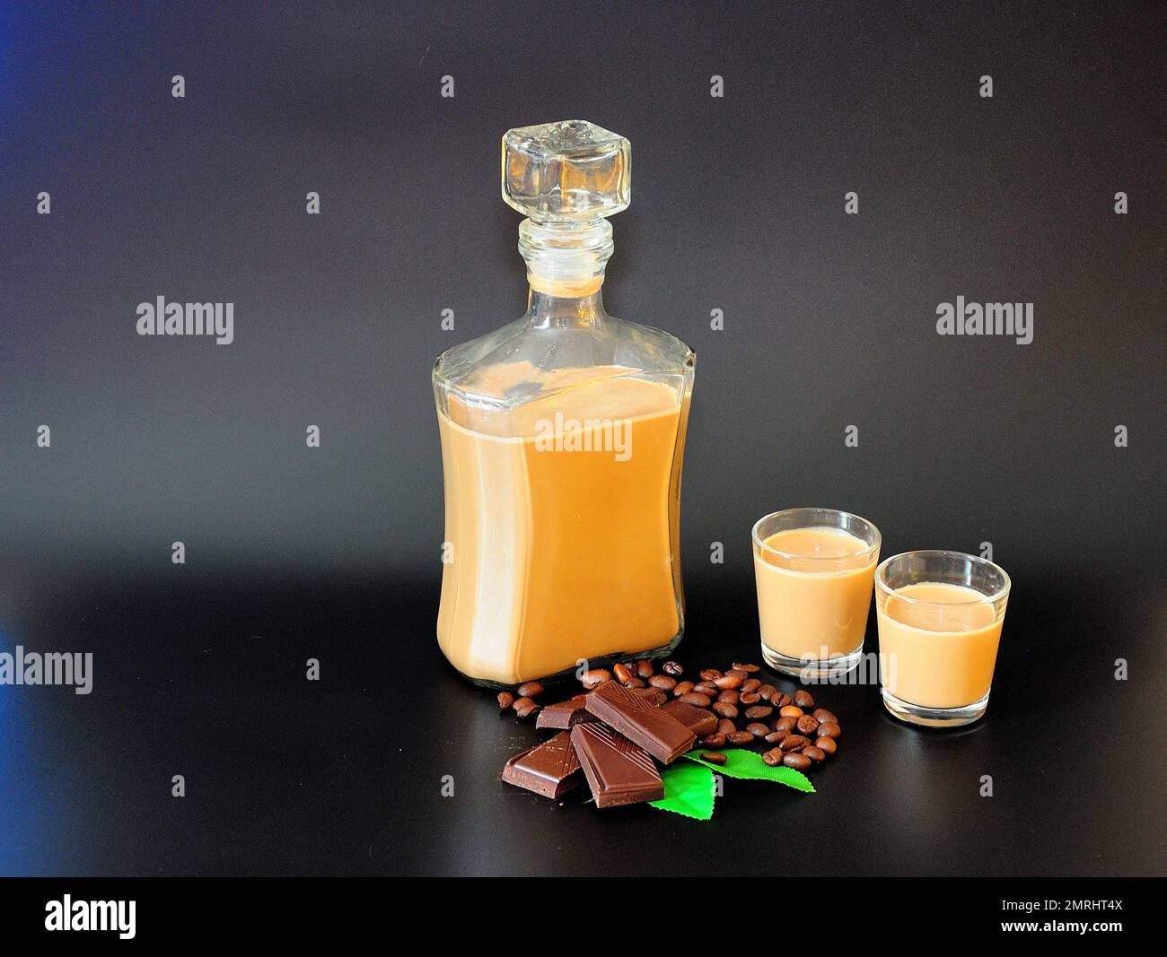 Traditional Irish cream liqueur in a bottle and two glasses on a black  background, next to pieces of chocolate, mint leaves and roasted coffee  beans Stock Photo - Alamy