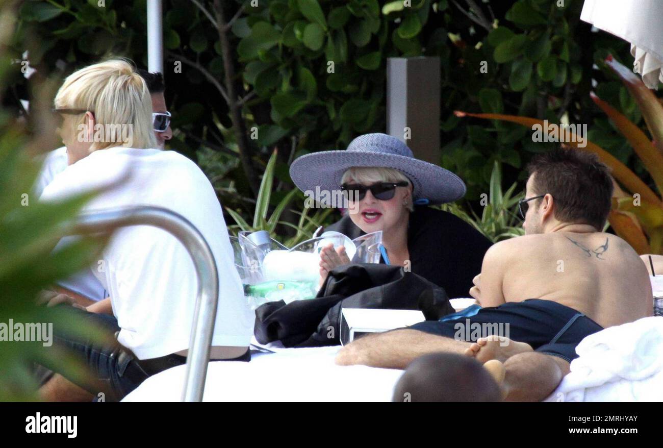 Kelly Osbourne chills out in a cabana poolside with fiance Luke Worrall ...