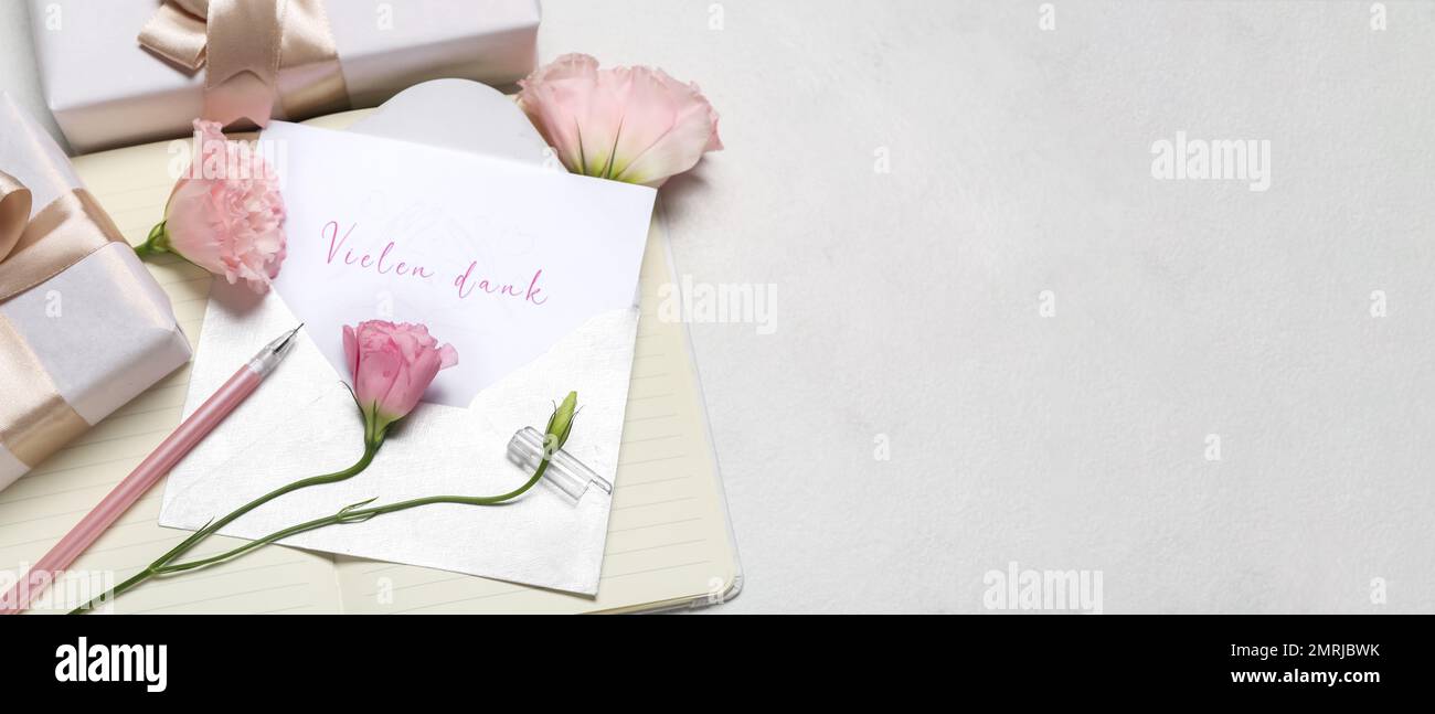 Card with text VIELEN DANK, envelope, notebook, gifts and eustoma flowers on light background with space for text Stock Photo