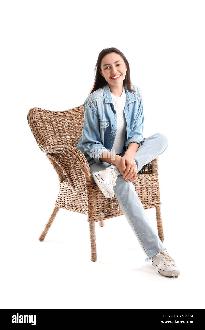 Young woman sitting in wicker armchair on white background Stock Photo ...
