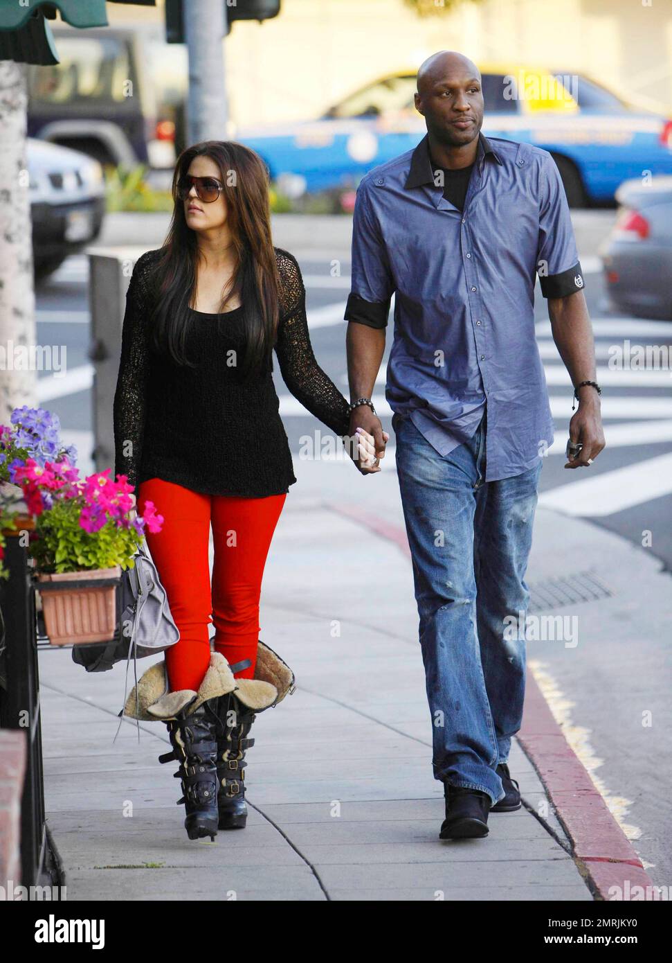 In a pair of bright red leggings, a black crochet top and fuzzy-lined high heel platform buckle-detailed boots reality TV star Khloe Kardashian holds hands with husband, LA Lakers basketball player Lamar Odom, as they stroll down the street.  The couple's new E! Network reality show 'Khloe & Lamar' premieres on April 10th and Khloe recently said of the premiere, 'I can't believe the premiere is less than a month away - so excited and so nervous! I'm dying with anticipation.' Los Angeles, CA. 03/15/11. Stock Photo