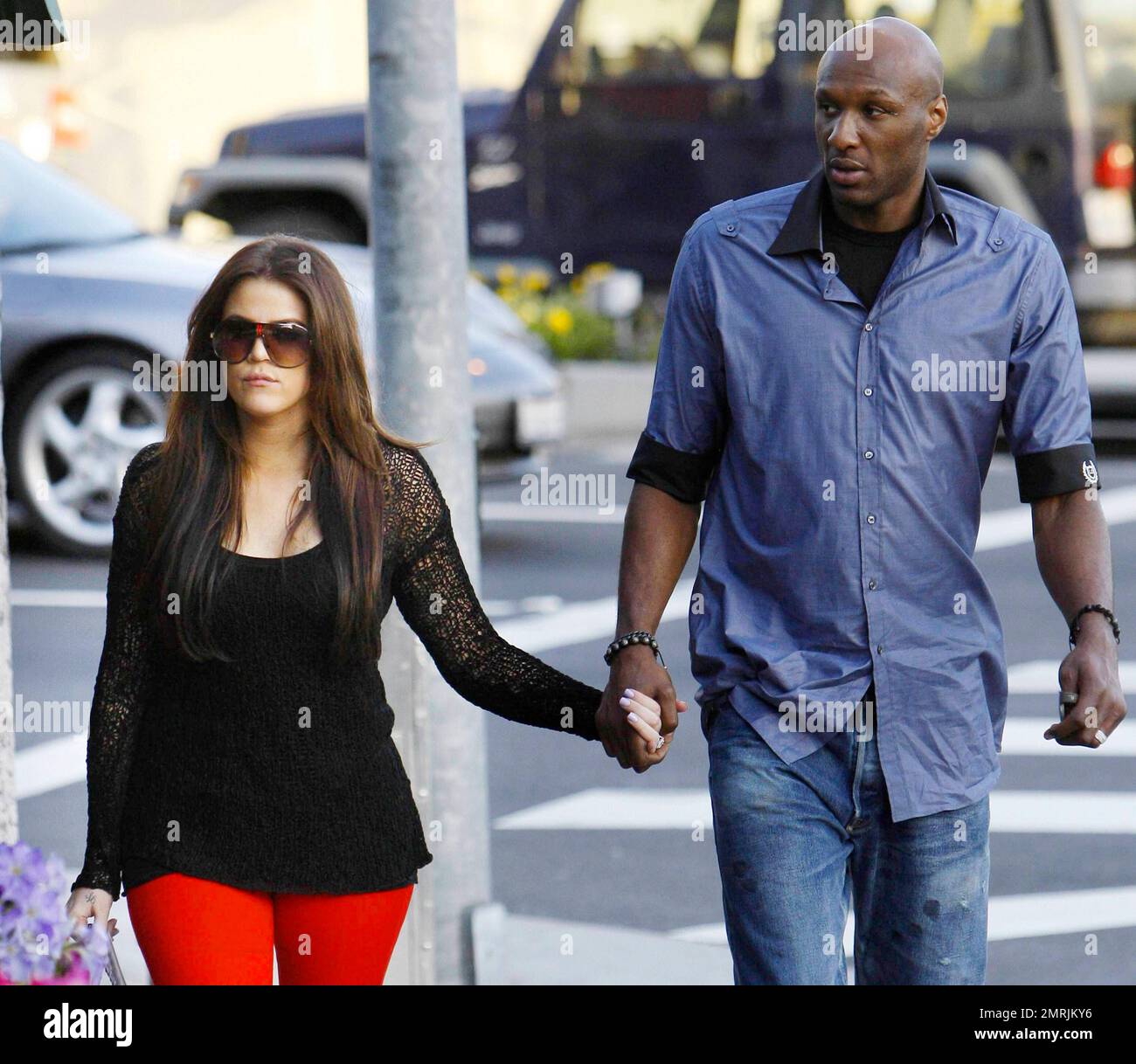 In a pair of bright red leggings, a black crochet top and fuzzy-lined high heel platform buckle-detailed boots reality TV star Khloe Kardashian holds hands with husband, LA Lakers basketball player Lamar Odom, as they stroll down the street.  The couple's new E! Network reality show 'Khloe & Lamar' premieres on April 10th and Khloe recently said of the premiere, 'I can't believe the premiere is less than a month away - so excited and so nervous! I'm dying with anticipation.' Los Angeles, CA. 03/15/11. Stock Photo