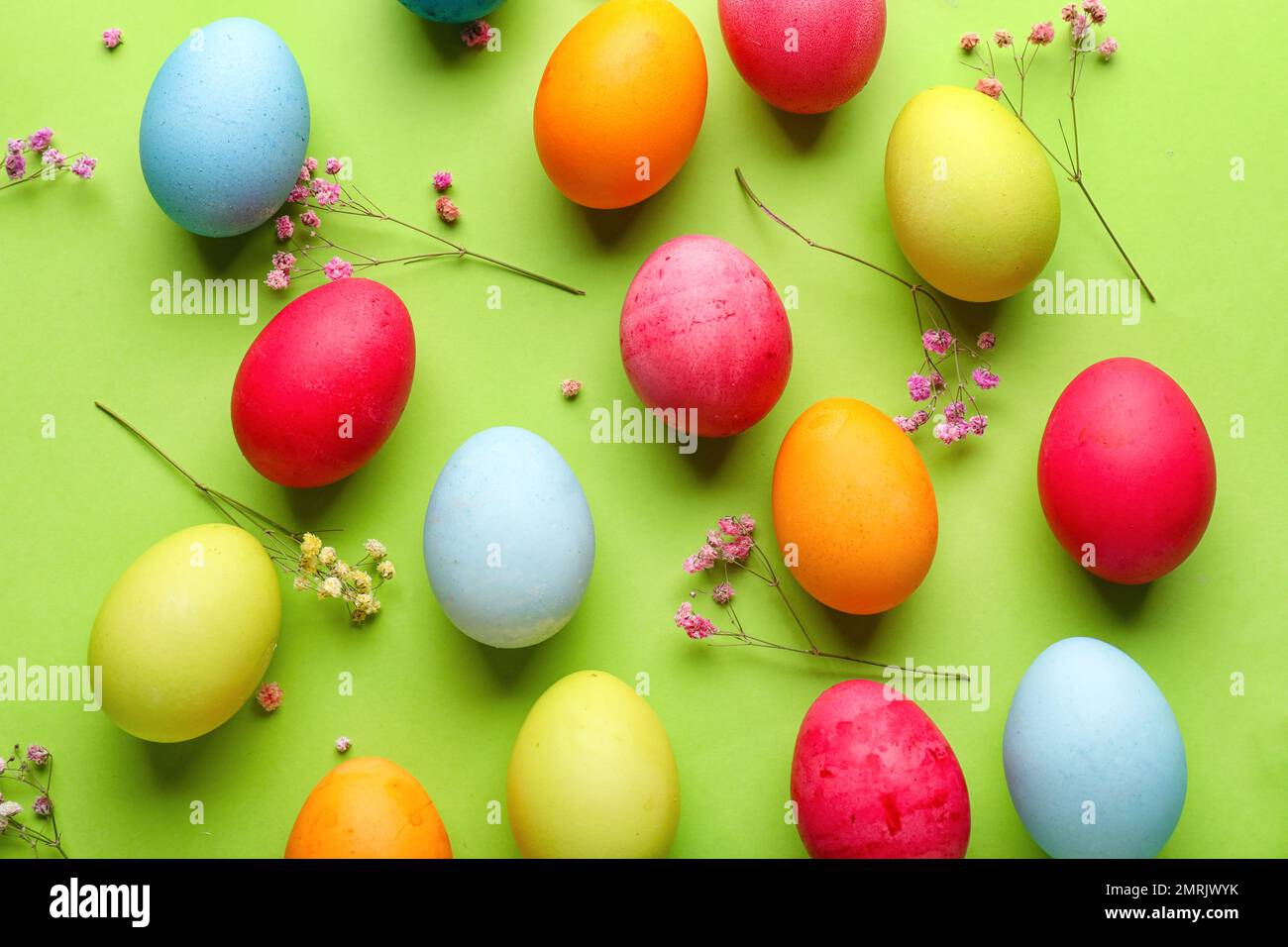 Composition with painted Easter eggs and gypsophila flowers on green ...