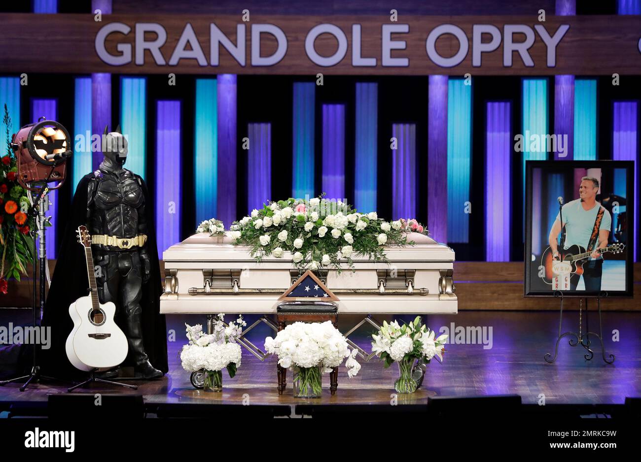 A Batman costume and guitar appear next to the casket during a memorial(01)