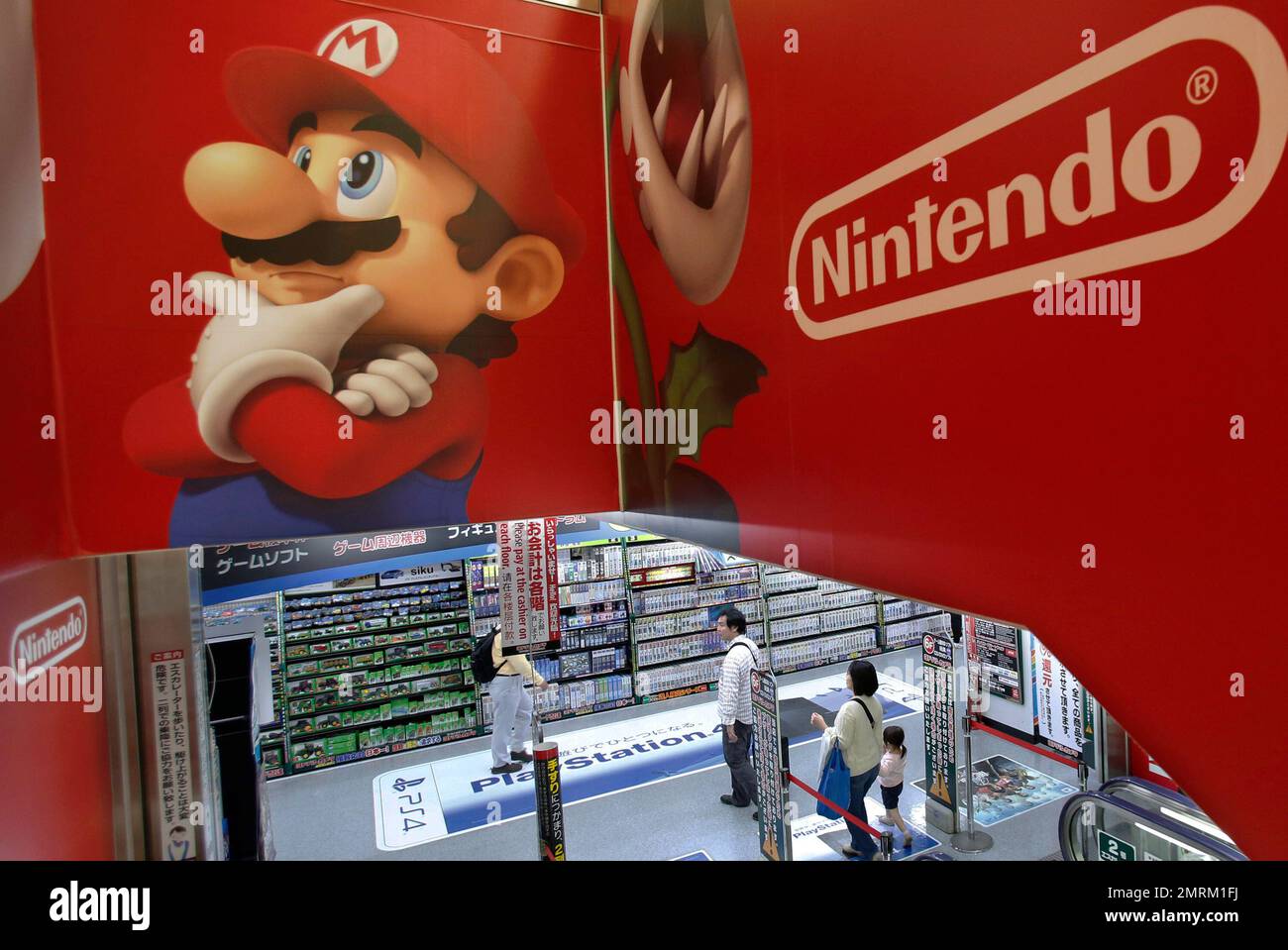 FILE - In this May 7, 2014, file photo, shoppers walk under the logo of ...