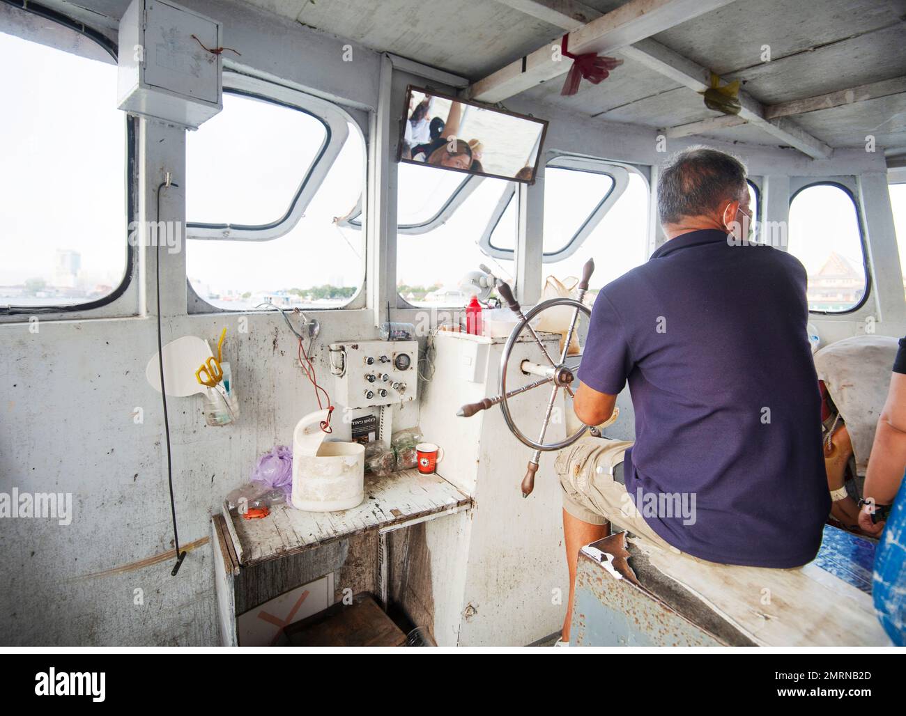 Bangkok,Thailand-December 09 2022: Working on the Phraya River,the operator of a small ferry craft takes passengers to and fro,many times a day,at the Stock Photo