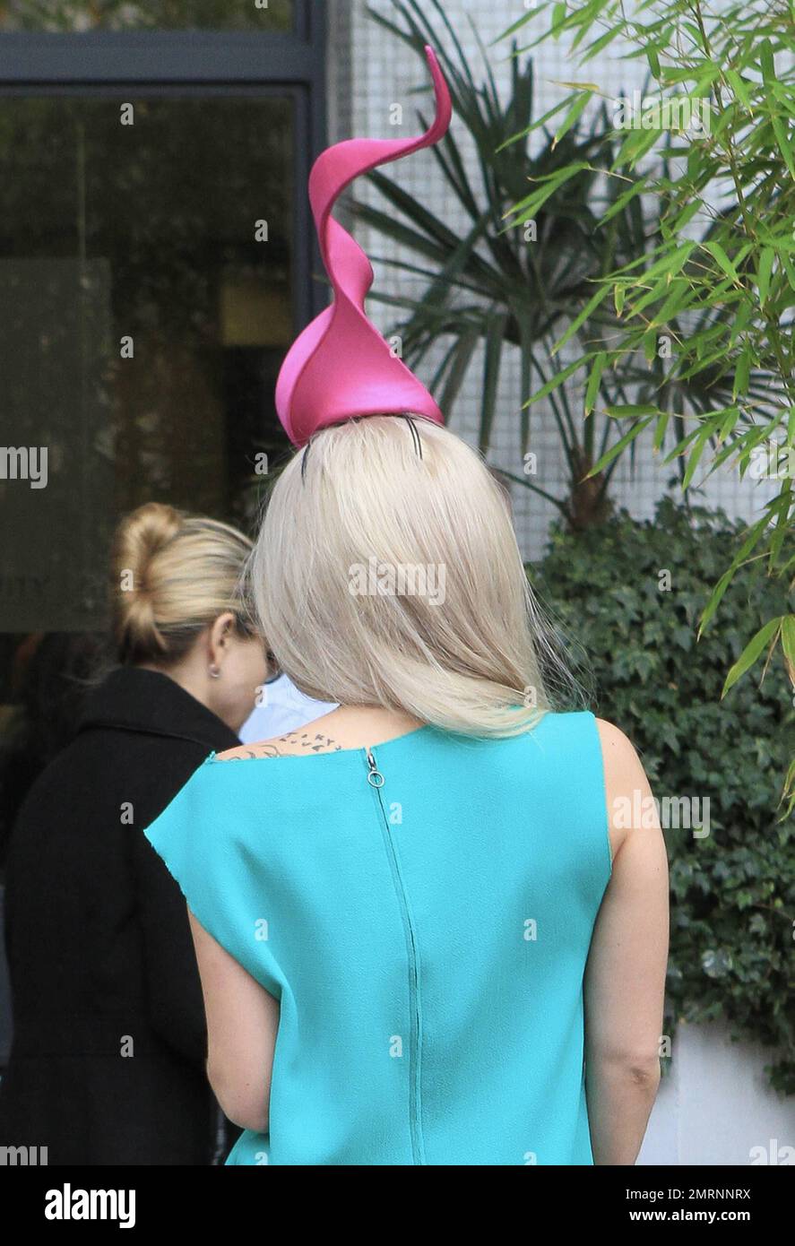 Lady Gaga is seen leaving her London hotel in a colorful green and hot pink  dress accessorized with an interesting headpiece, large round sunglasses  and black high heels and headed over to