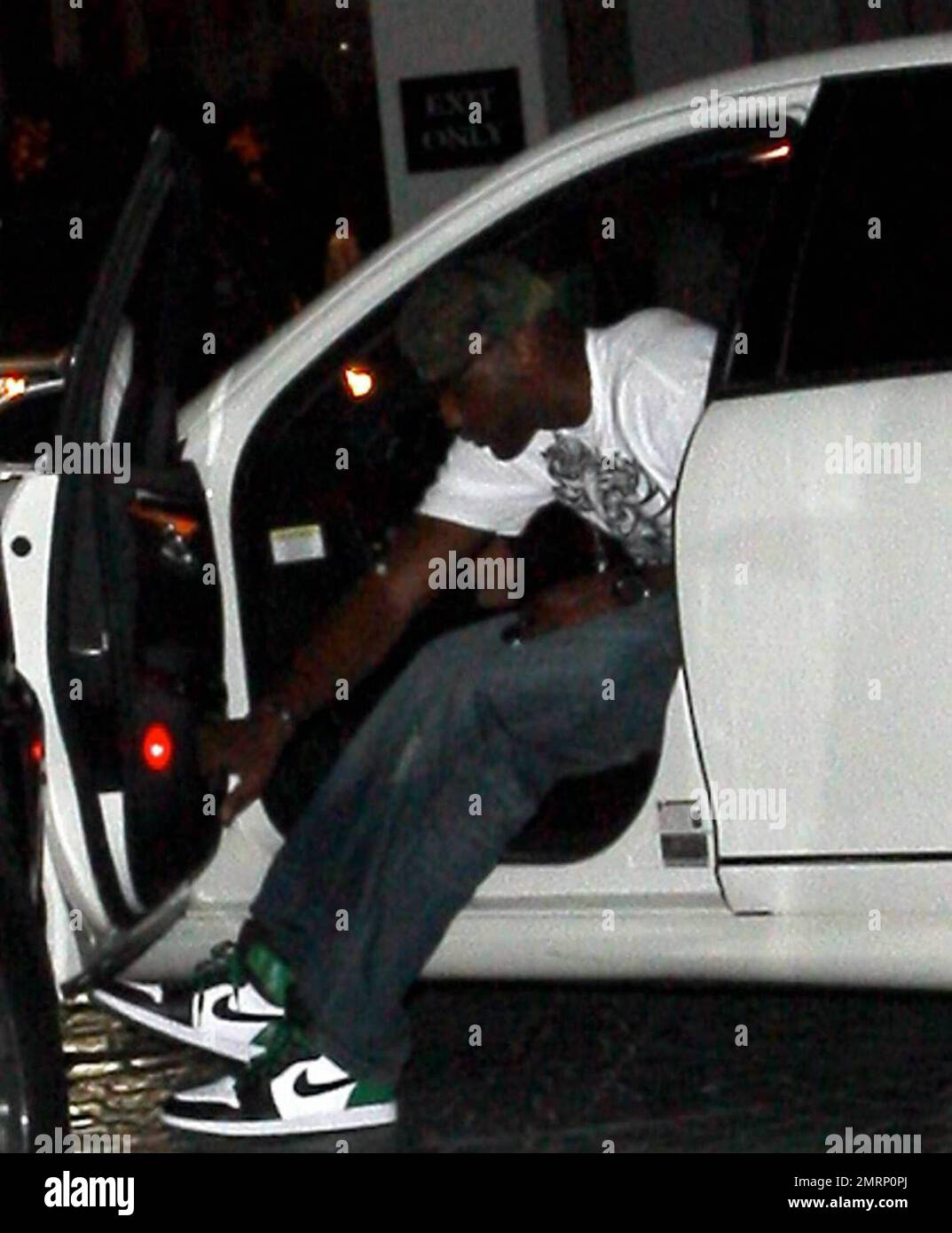 EXCLUSIVE!! Khloe Kardashian's new husband, LA Lakers player Lamar Odom, is alone as he leaves the hotel where the couple spent their first night together as husband and wife earlier this week. Odom, carrying a bottle of perfume or cologne and wearing jeans, a t shirt and sneakers, waves his hat as he gets in his car to leave. Los Angeles, CA. 10/2/09. Stock Photo
