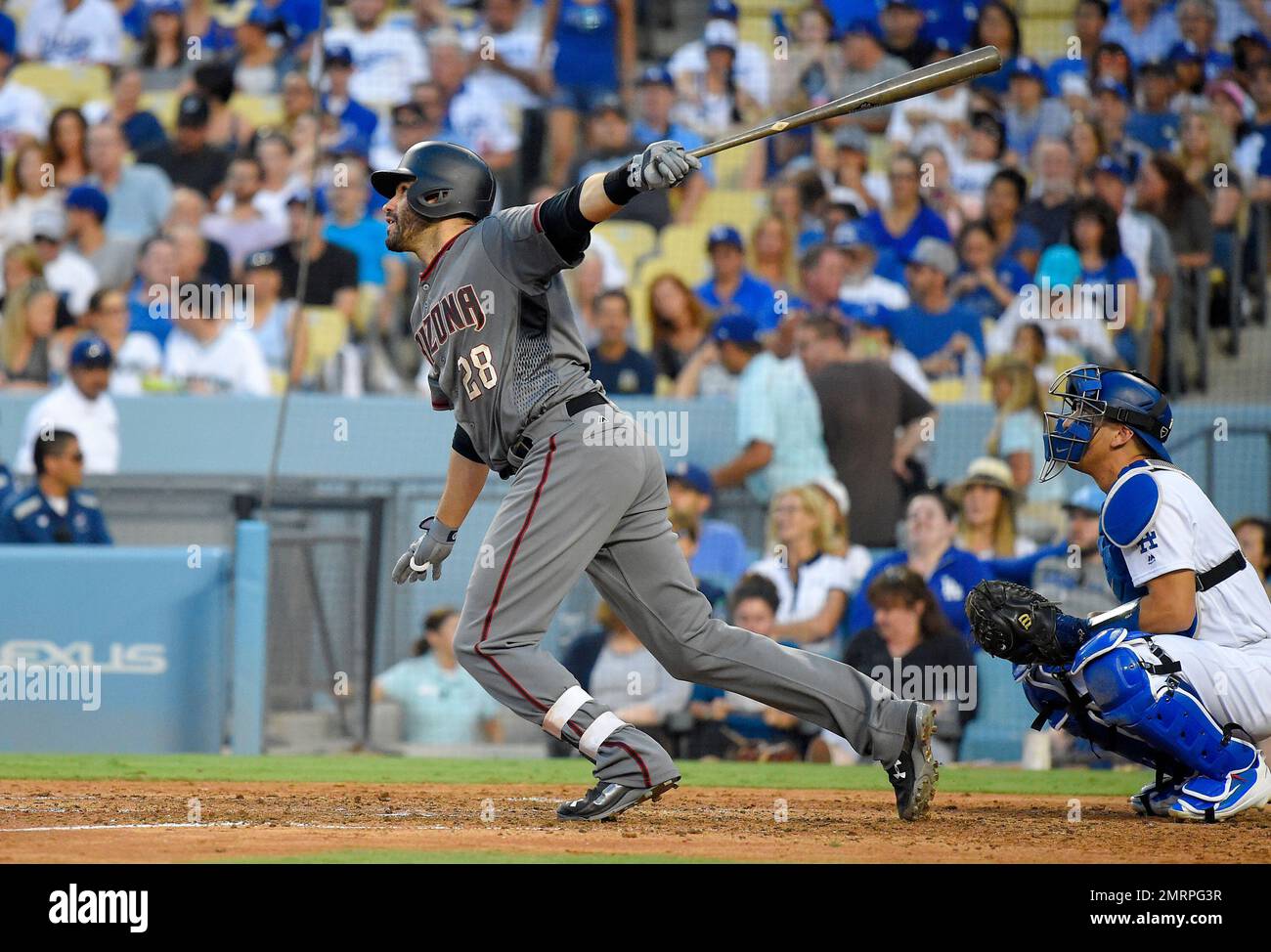 Arizona Diamondbacks' J.D. Martinez, left, runs to first as he hits a solo  home run while Los Angeles Dodgers relief pitcher Josh Fields watches  during the eighth inning of a baseball game