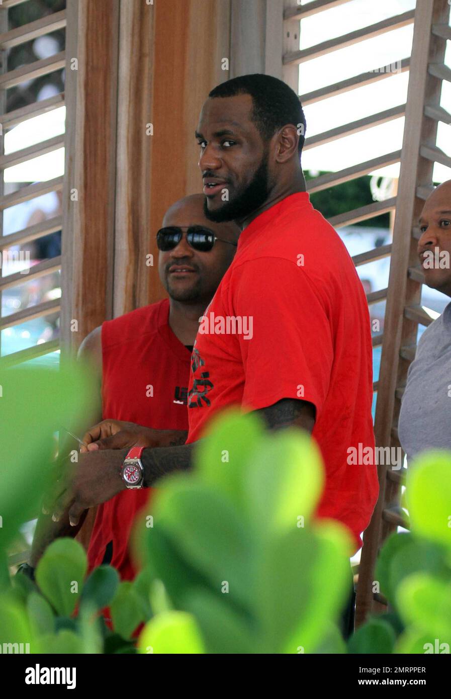 Lebron James pulls his shirt on following a day at the pool. Miami, FL