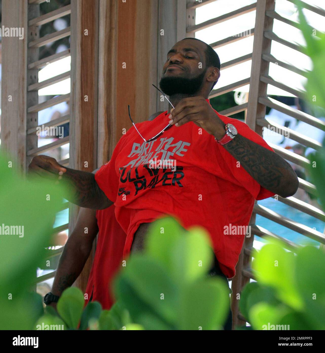 Lebron James pulls his shirt on following a day at the pool. Miami, FL