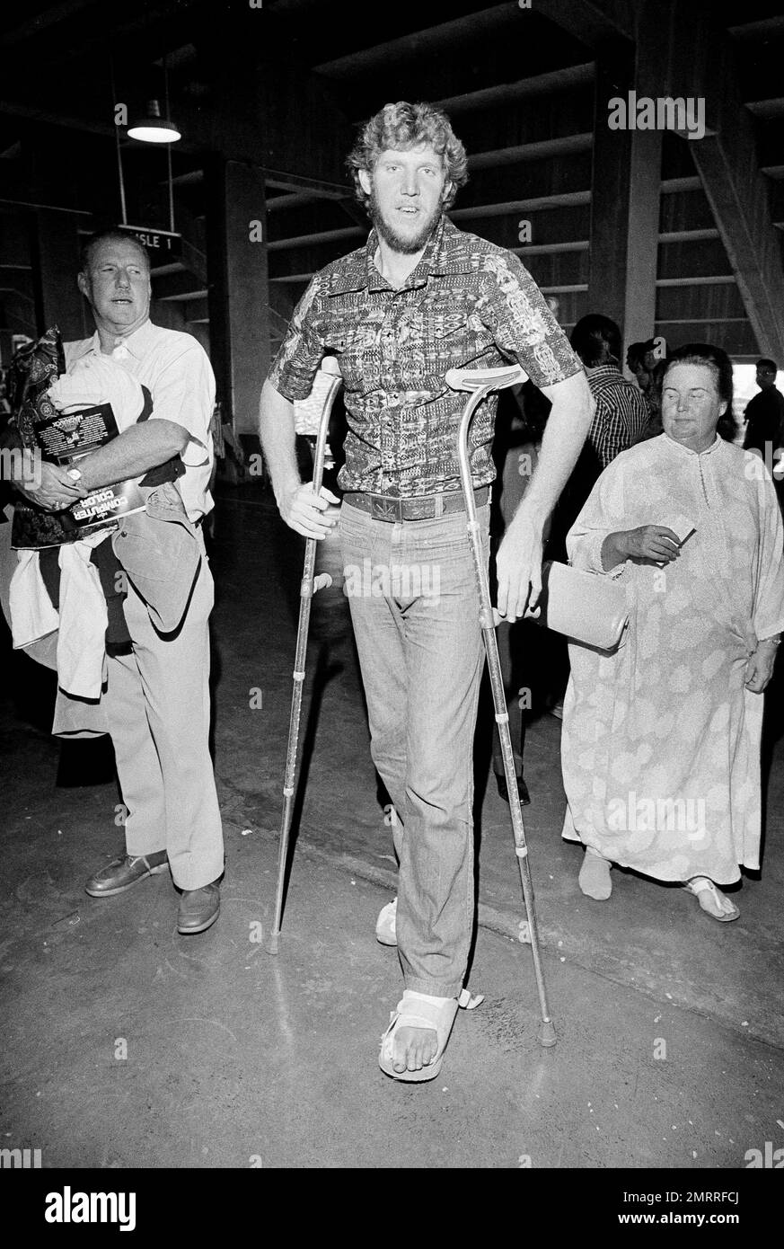 Pro basketball star Bill Walton rests on his crutches in Los Angeles as he waits for an elevator to take him to this seat section in Dodger Stadium where he'll watch the sixth game of the World Series, Oct. 17, 1978. (AP Photo) Stock Photo