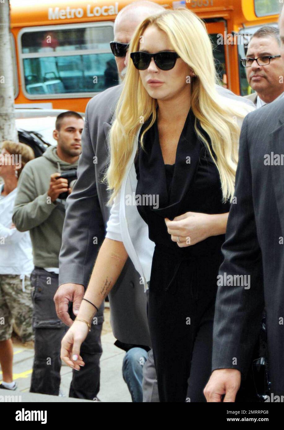 Troubled actress Lindsay Lohan, who shows scars on her arms, arrives at a Beverly Hills municipal court after lunch recess and later leaves looking sad holding her sister Ali's hand.  At the court proceedings Lohan was sentenced to 90 days in jail and a 90-day inpatient rehabilitation program to follow.  Todays hearing, which was to determine if Lohan violated probation on a three-year-old drink driving arrest, is just one of several that have been scheduled for the starlet whose nightlife and rule-breaking reputation seems to have eclipsed her acting career.æ According to reports Lohan's hear Stock Photo