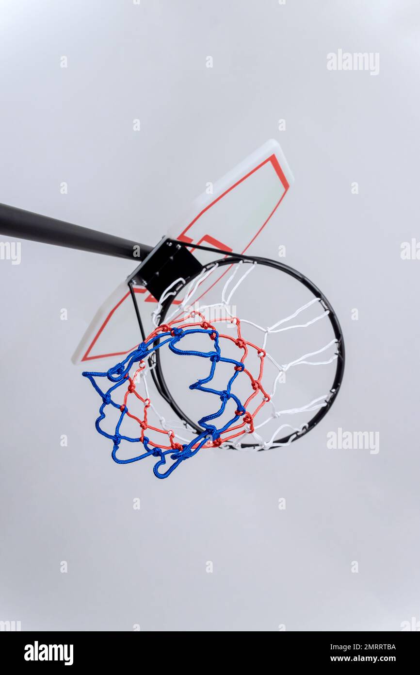 On white background basketball basket hoop is placed in top of rim with net hanging from it Stock Photo