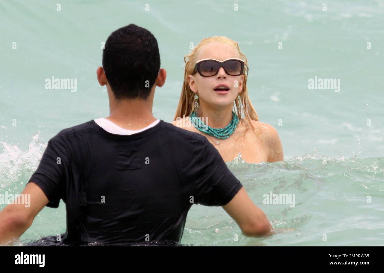 Troubled American starlet Lindsay Lohan enjoys a dip in the warm ocean with  her entourage that included younger sister Ali. A laughing Lohan lost her  bikini top in the rough waves giving