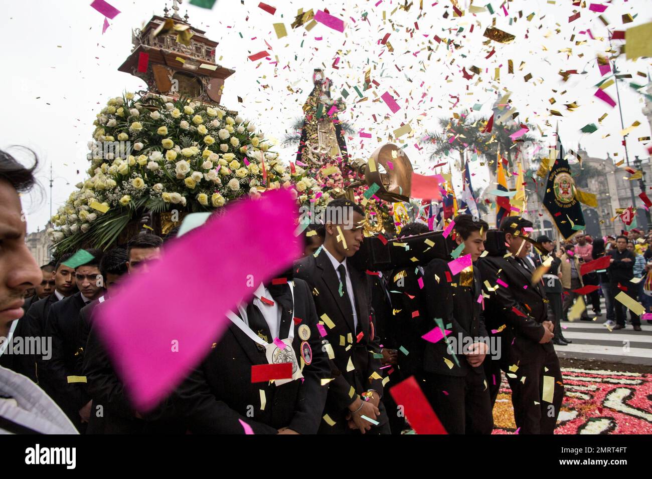 Confetti fills the air as men carry a statue of Santa Rosa de Lima in ...