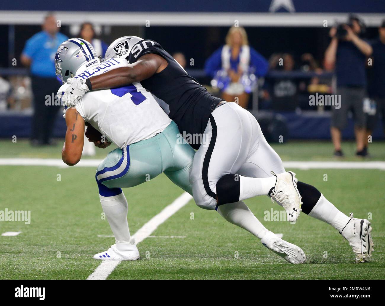 Dallas Cowboys quarterback Dak Prescott (4) is sacked by Oakland Raiders  defensive tackle Treyvon Hester (90) in the first half of a preseason NFL  football game, Saturday, Aug. 26, 2017, in Arlington,