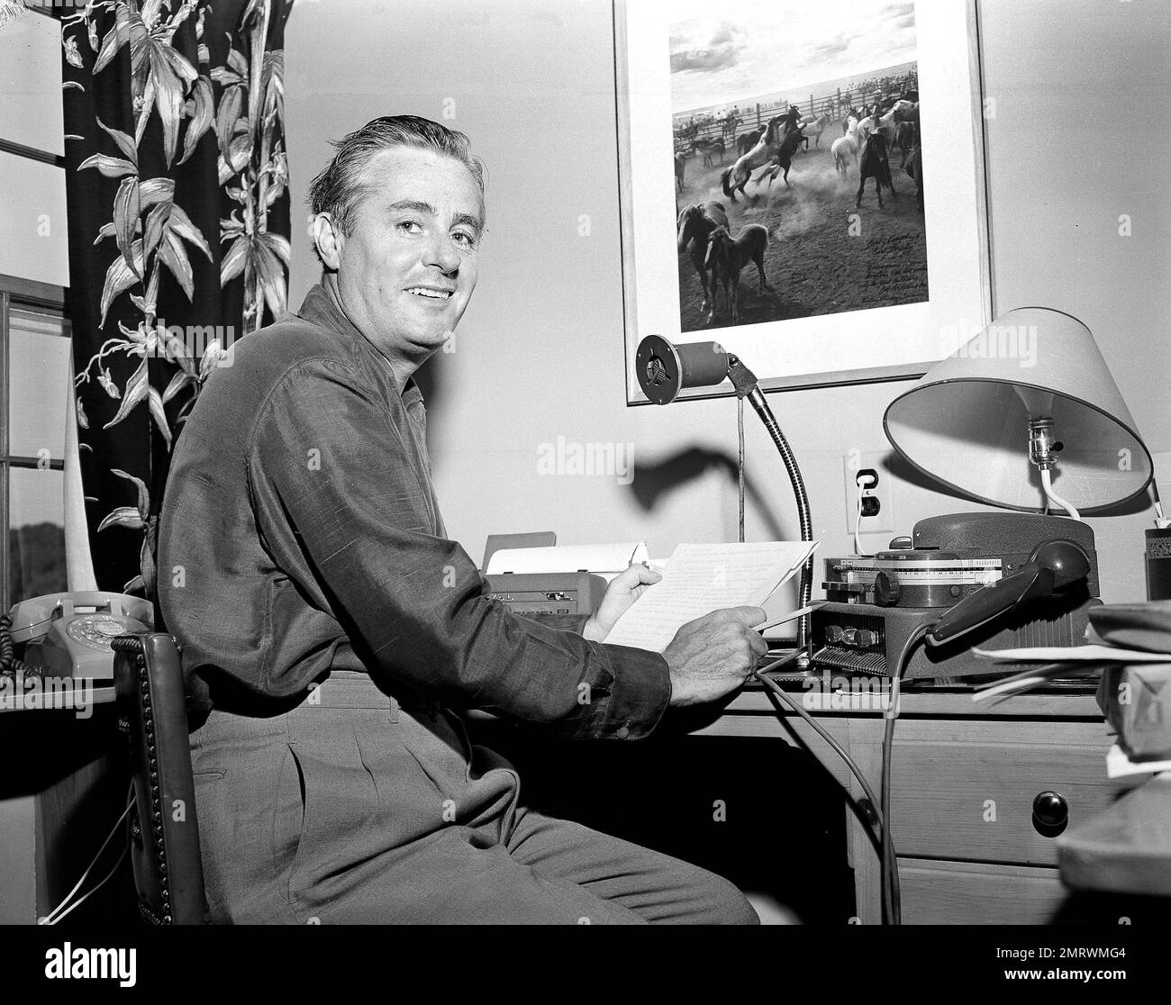 Curt Gowdy, popular radio and television voice of the Boston Red Sox, makes a broadcast from the bedroom of his Wellesley, Mass., home, June 24, 1957