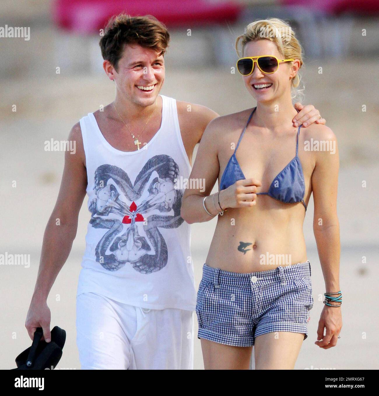Take That singer Mark Owen and wife Emma Ferguson enjoy a romantic barefoot morning stroll on the beach while continuing their holiday in the Caribbean.  In a white sleeveless shirt and shorts Mark held hands with Emma, clad in tiny shorts and a bikini top, and later wrapped his arm around her shoulders.  Looking very much in love Emma kissed Mark on the shoulder and played with his hair.  Later the pair stopped so Mark could pose for a picture with a young fan. Owen and his fellow Take That band members, Gary Barlow, Howard Donald and Jason Orange, are reportedly on the tropical island to per Stock Photo