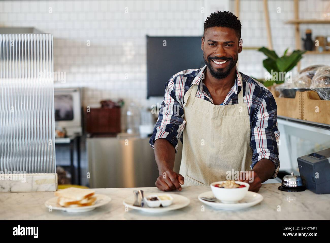 We serve delicious, healthy breakfasts. Cropped portrait of a handsome young man working in a cafe. Stock Photo