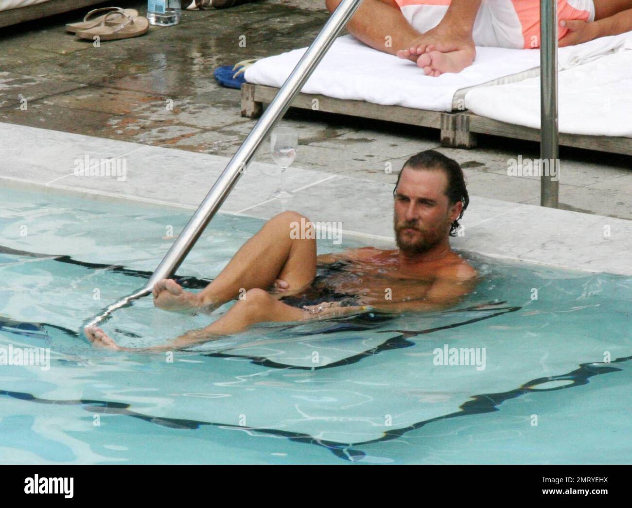 Exclusive!! Matthew McConaughey winds down from a beach side workout by doing stretch exercises in his hotel pool under the admiring glances of female guests, Miami Beach, FL, 8/23/06 Stock Photo