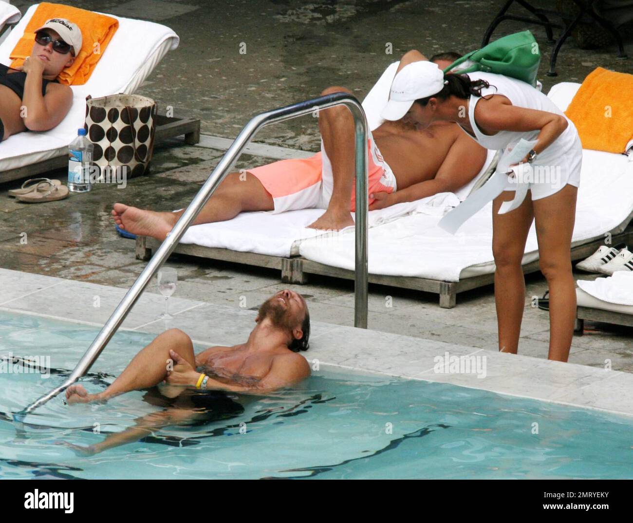 Exclusive!! Matthew McConaughey winds down from a beach side workout by doing stretch exercises in his hotel pool under the admiring glances of female guests, Miami Beach, FL, 8/23/06 All Stock Photo