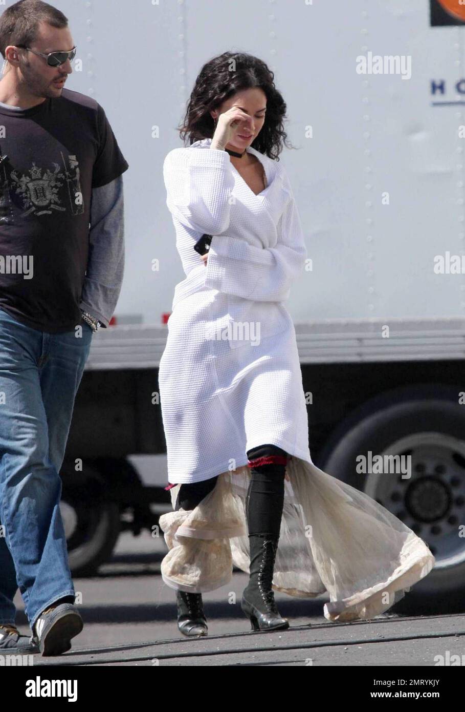 Exclusive Megan Fox films on location in Sylmar CA this morning. She was seen walking to the set with a white robe covering a frilly cowboy western style dress complete with boots and