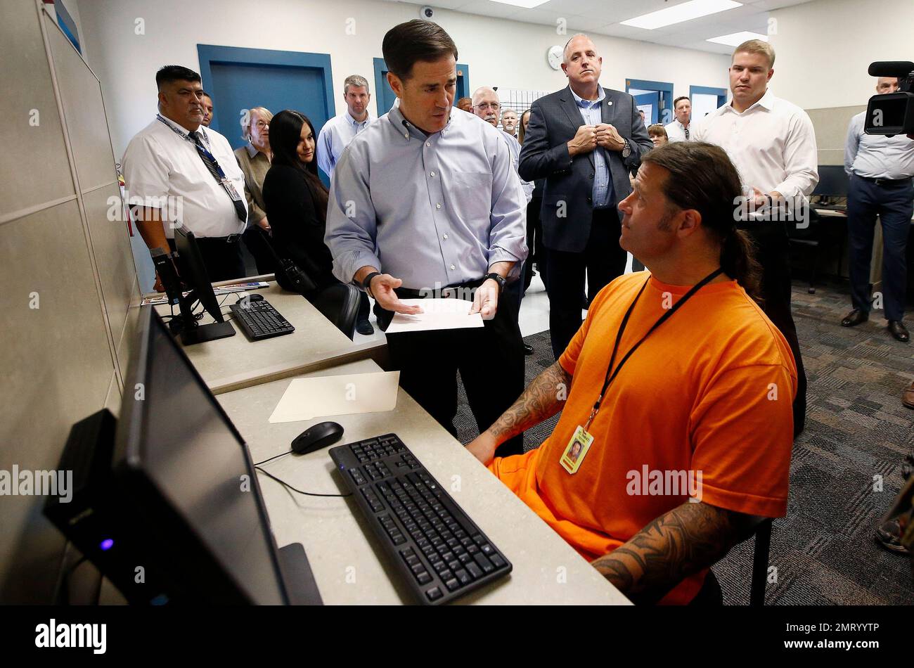 Arizona Republican Gov. Doug Ducey, left, speaks with inmate Jay 