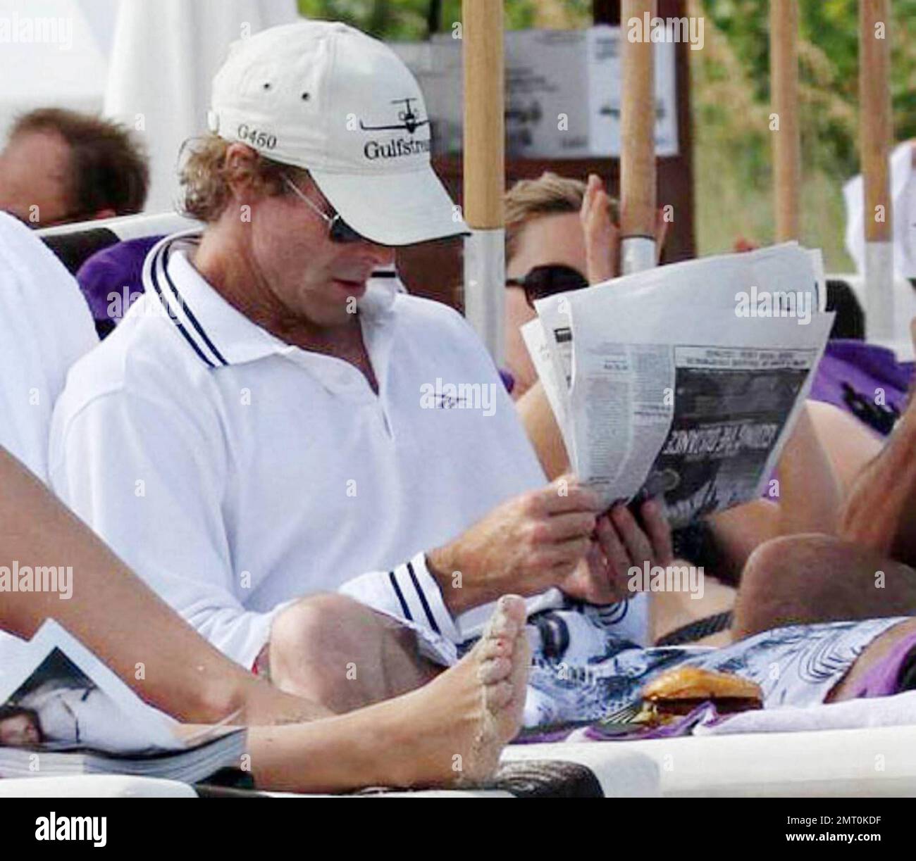 Blockbuster-making director Michael Bay hangs out at the beach with some friends over the Labor Day long weekend.  Bay, who is currently filming 'Transformers 3', showed off his trim physique as he put his shirt on before enjoying a newspaper followed by a burger and french fry lunch.  Bay has recently been in the news as he reportedly pledged a $50,000 reward to anyone who will identify a mystery woman who was video taped throwing live puppies in to a river, a video that can be seen on such websites as YouTube. Miami, FL. 09/04/10. Stock Photo