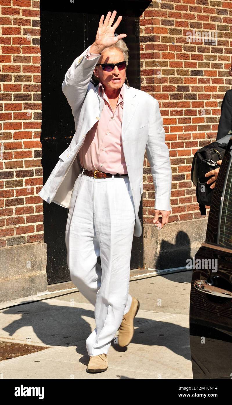 Dressed in a white linen suit and pink shirt Michael Douglas