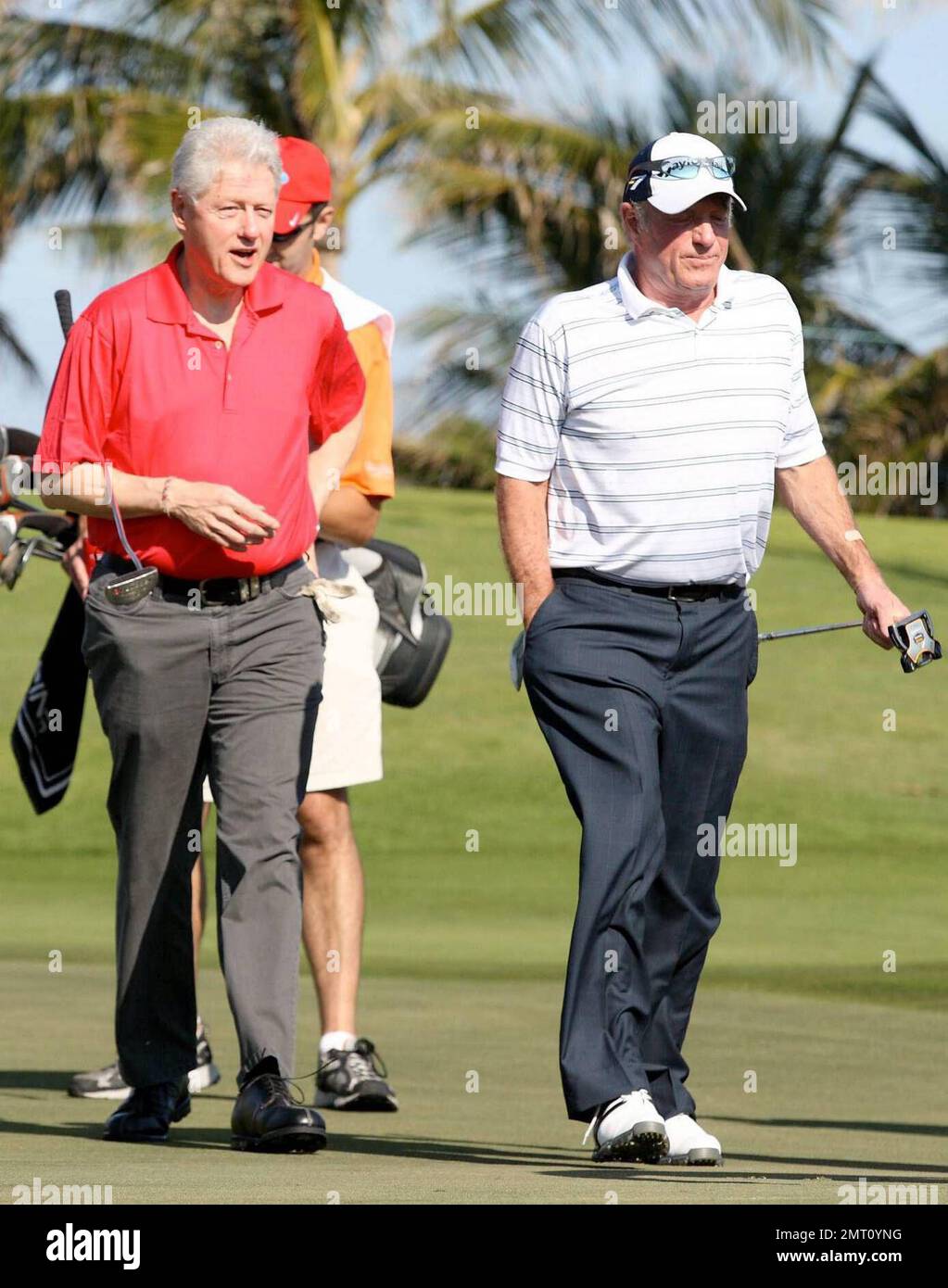 Exclusive!! President Bill Clinton and James Caan play on day three of The Michael Jordan Celebrity Invitational golf tournament held at the luxurious One and Only Ocean Club Golf Course on Paradise Island. At one point, Young hit one into the rough which, in this case, was the beach on the other side of a wall! He worked very hard to get it back onto the course. At least it didn't end up in the ocean. The MJCI organization brings in an incredible array of talent from the worlds of sport and entertainment to compete on the course and participate in various events for charity in this annual eve Stock Photo