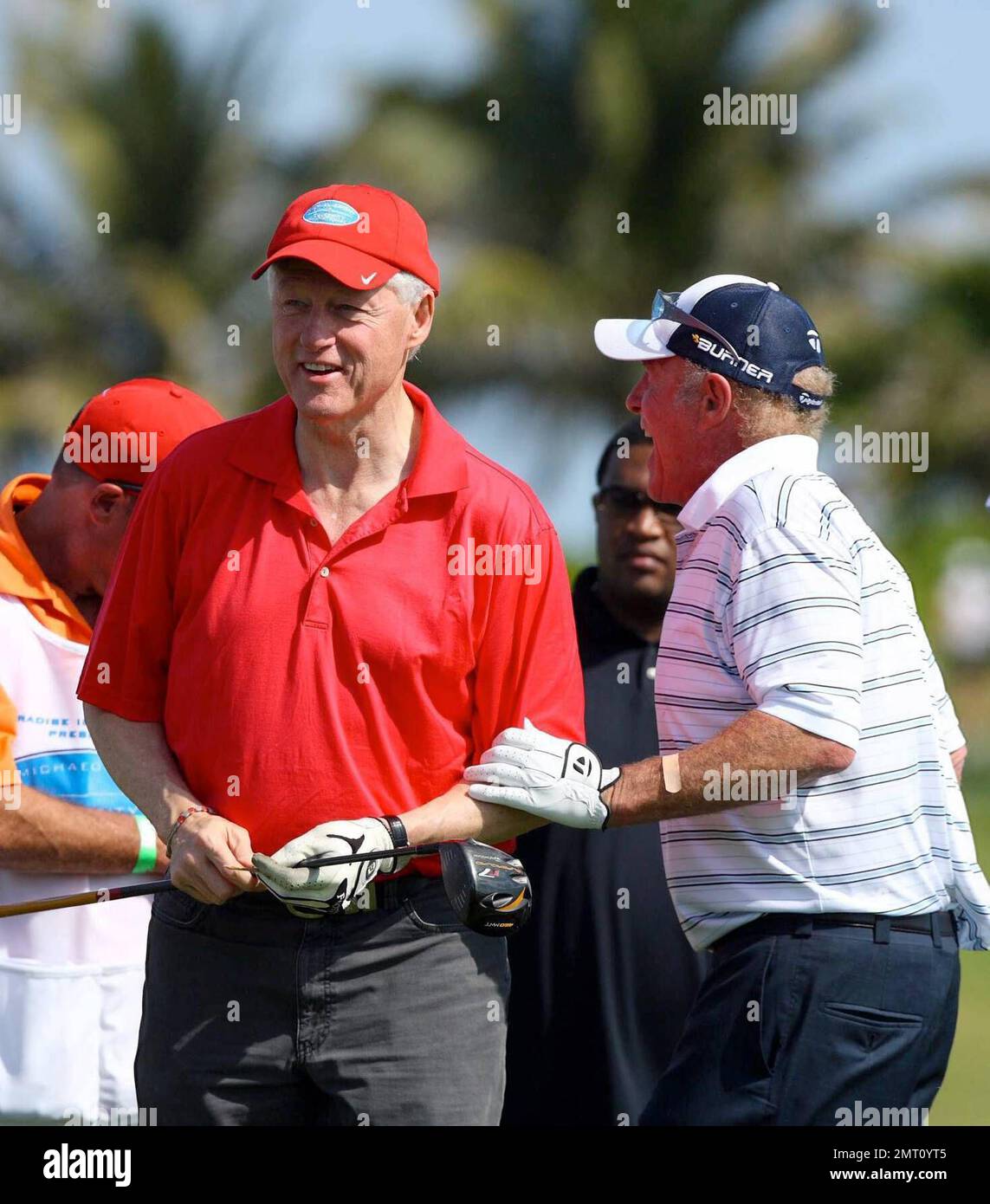 Exclusive!! President Bill Clinton and James Caan play on day three of The Michael Jordan Celebrity Invitational golf tournament held at the luxurious One and Only Ocean Club Golf Course on Paradise Island. At one point, Young hit one into the rough which, in this case, was the beach on the other side of a wall! He worked very hard to get it back onto the course. At least it didn't end up in the ocean. The MJCI organization brings in an incredible array of talent from the worlds of sport and entertainment to compete on the course and participate in various events for charity in this annual eve Stock Photo