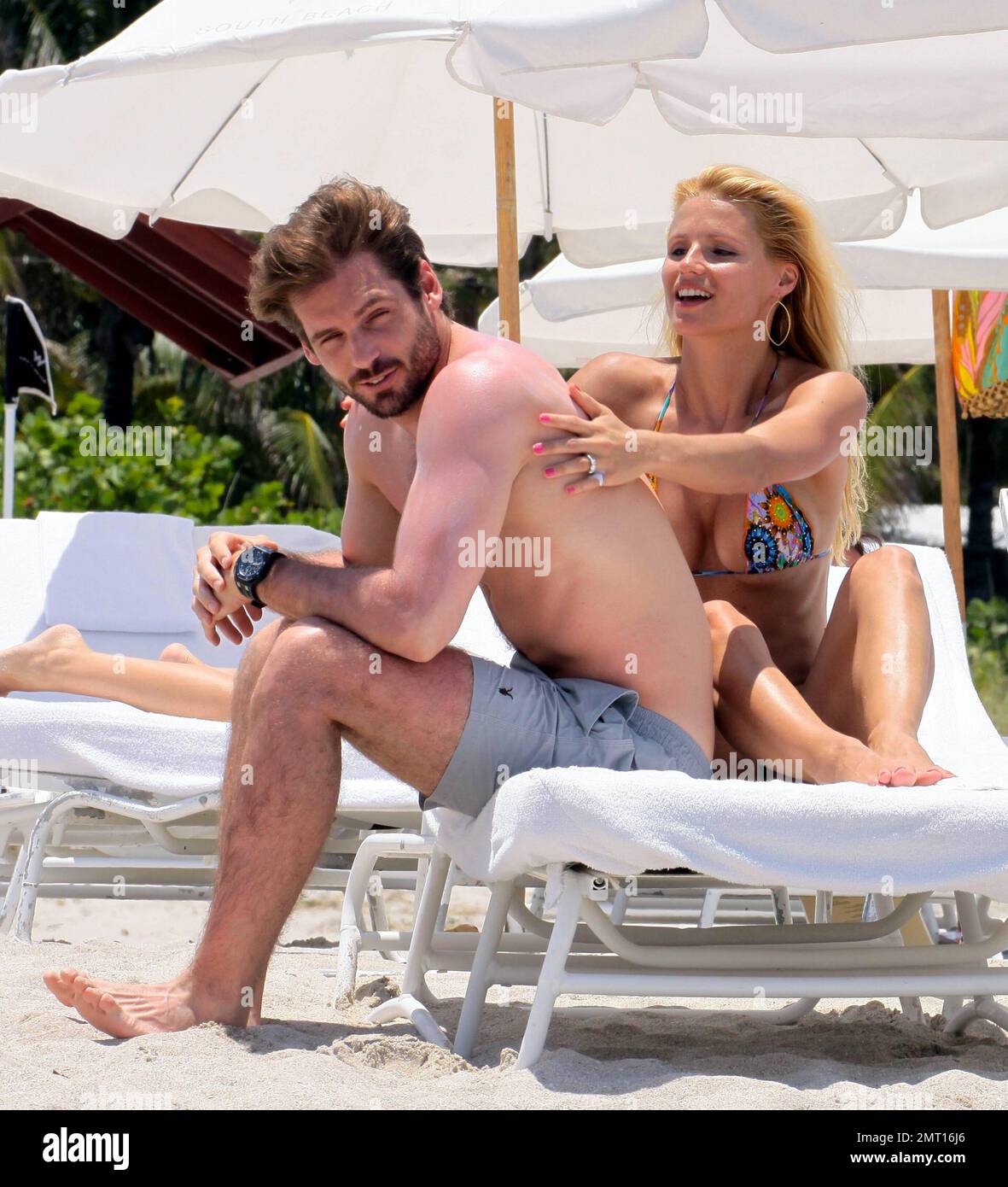 Swiss TV host and actress Michelle Hunziker spends the day in Miami Beach with boyfriend Tomaso Trussardi. 35 year old Hunziker wore a multi-color string bikini that showed off her amazing toned figure. The couple were seen taking a dip in the ocean, sharing a kiss and happily walking hand-in-hand. Miami Beach, FL. 3rd June 2012. Stock Photo