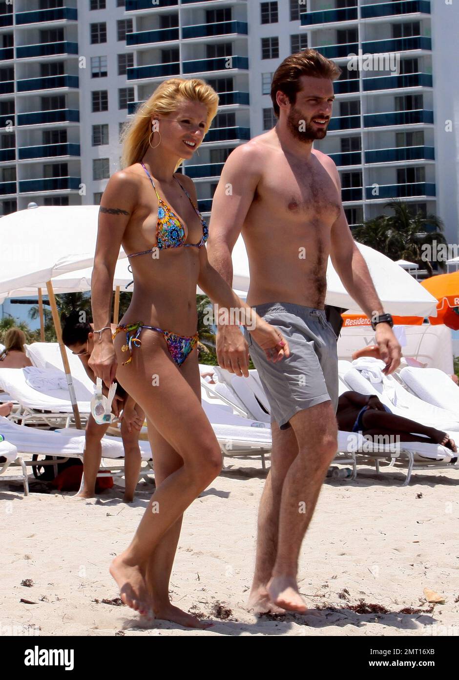 Swiss TV host and actress Michelle Hunziker spends the day in Miami Beach with boyfriend Tomaso Trussardi. 35 year old Hunziker wore a multi-color string bikini that showed off her amazing toned figure. The couple were seen taking a dip in the ocean, sharing a kiss and happily walking hand-in-hand. Miami Beach, FL. 3rd June 2012. . Stock Photo
