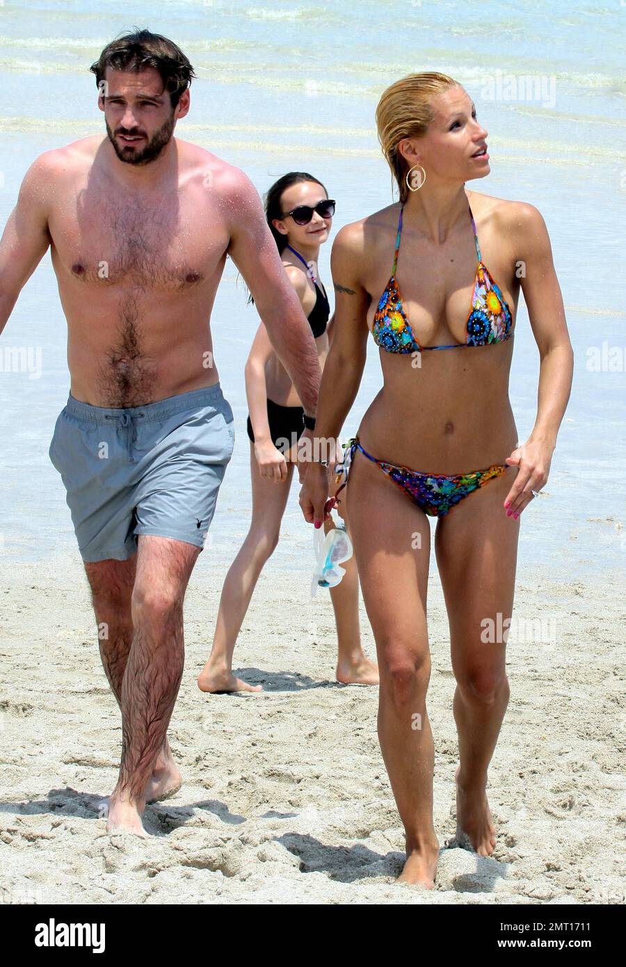 Swiss TV host and actress Michelle Hunziker spends the day in Miami Beach with boyfriend Tomaso Trussardi. 35 year old Hunziker wore a multi-color string bikini that showed off her amazing toned figure. The couple were seen taking a dip in the ocean, sharing a kiss and happily walking hand-in-hand. Miami Beach, FL. 3rd June 2012. . Stock Photo