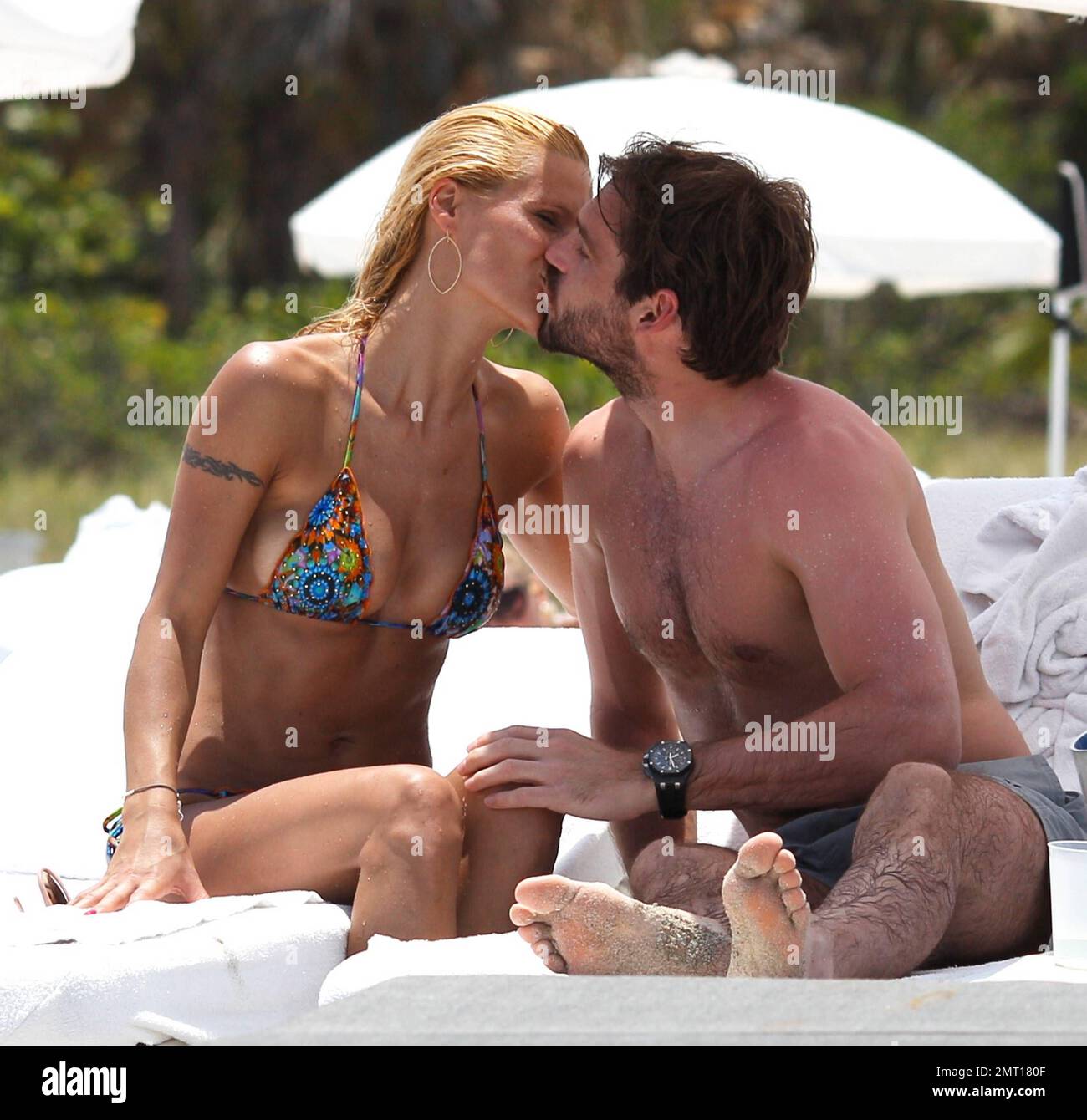 Swiss TV host and actress Michelle Hunziker spends the day in Miami Beach with boyfriend Tomaso Trussardi. 35 year old Hunziker wore a multi-color string bikini that showed off her amazing toned figure. The couple were seen taking a dip in the ocean and happily walking hand-in-hand. Miami Beach, FL. 3rd June 2012. Stock Photo