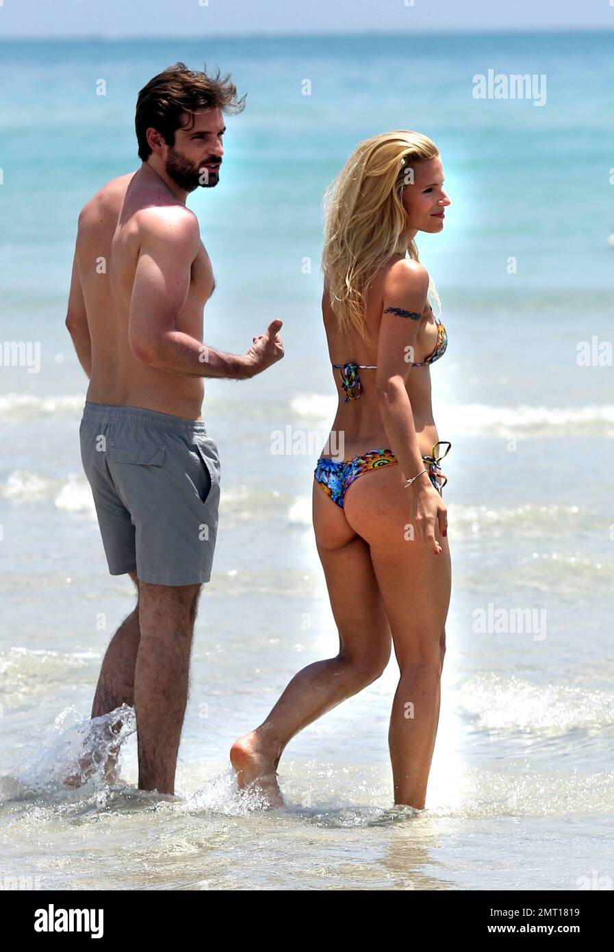 Swiss TV host and actress Michelle Hunziker spends the day in Miami Beach with boyfriend Tomaso Trussardi. 35 year old Hunziker wore a multi-color string bikini that showed off her amazing toned figure. The couple were seen taking a dip in the ocean and happily walking hand-in-hand. Miami Beach, FL. 3rd June 2012. Stock Photo