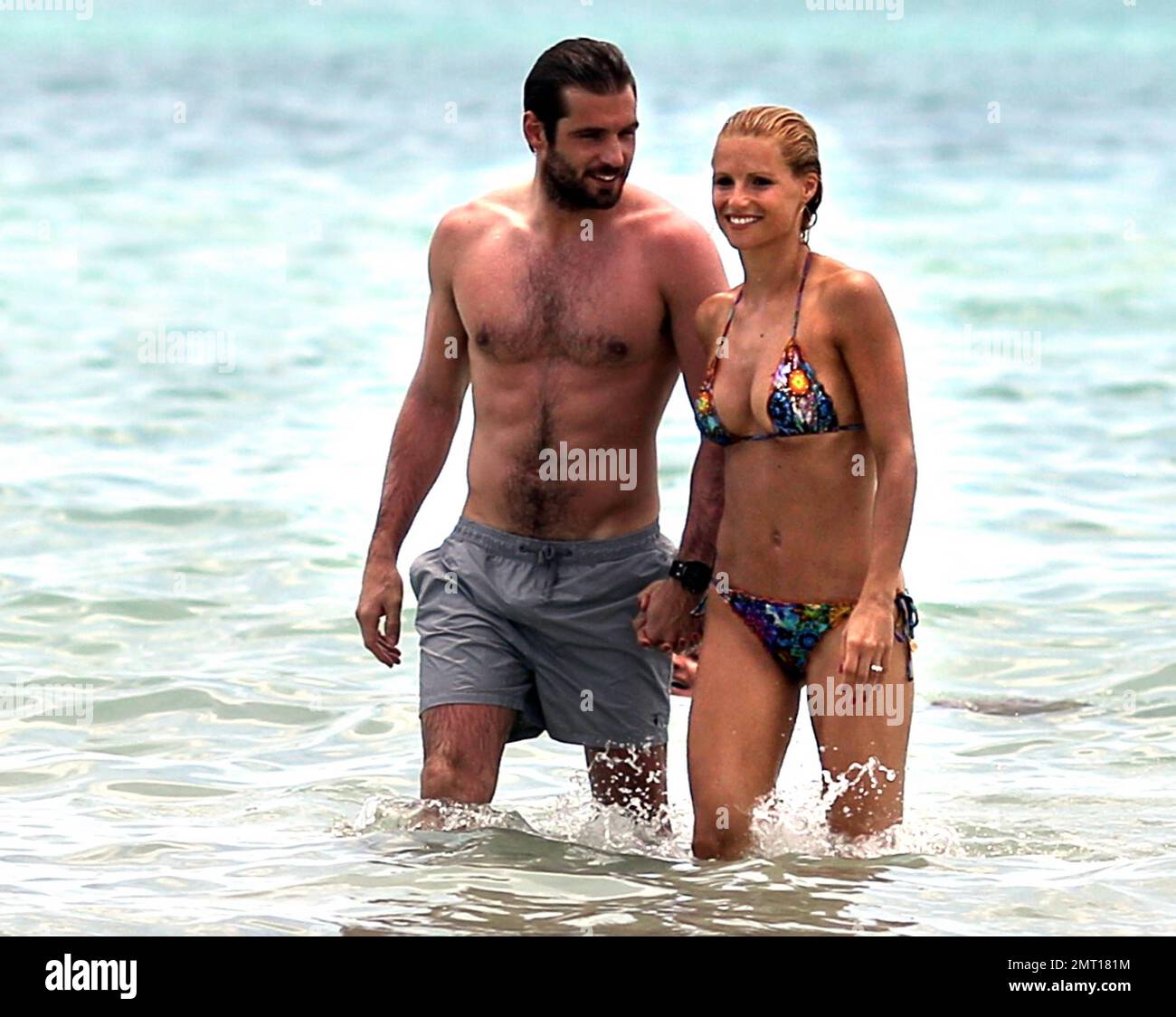 Swiss TV host and actress Michelle Hunziker spends the day in Miami Beach with boyfriend Tomaso Trussardi. 35 year old Hunziker wore a multi-color string bikini that showed off her amazing toned figure. The couple were seen taking a dip in the ocean and happily walking hand-in-hand. Miami Beach, FL. 3rd June 2012. Stock Photo
