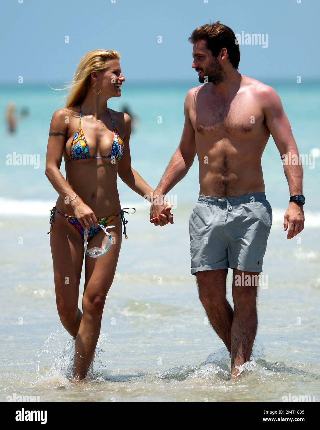 Swiss TV host and actress Michelle Hunziker spends the day in Miami Beach with boyfriend Tomaso Trussardi. 35 year old Hunziker wore a multi-color string bikini that showed off her amazing toned figure. The couple were seen taking a dip in the ocean and happily walking hand-in-hand. Miami Beach, FL. 3rd June 2012. . Stock Photo