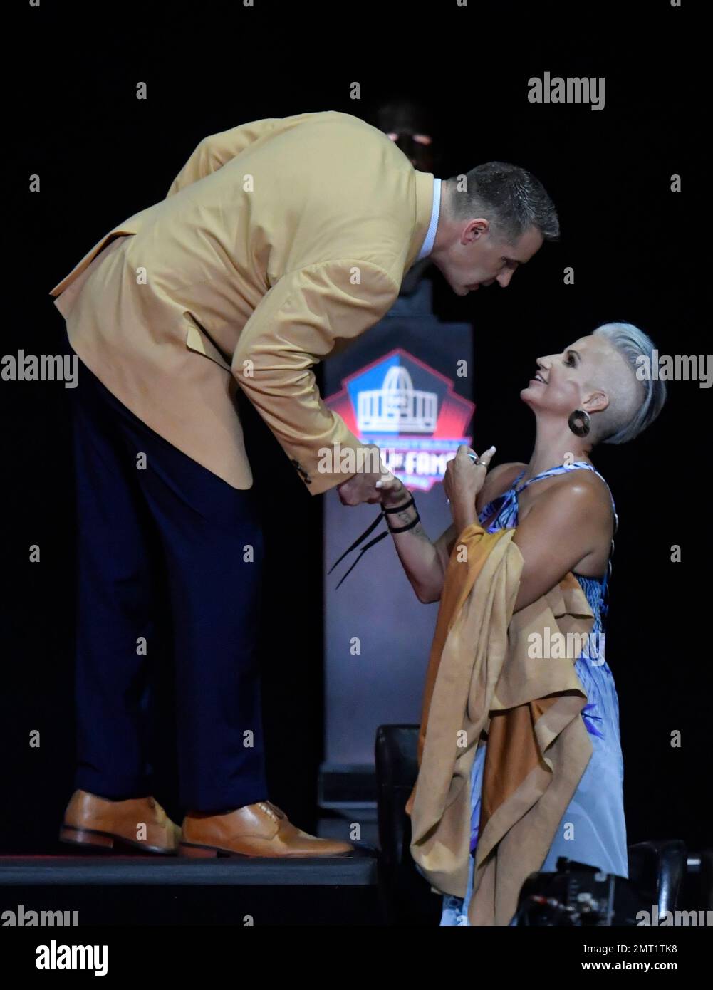 Brenda Warner, wife of former NFL quarterback Kurt Warner, helps De'Niya  Moore (4) zip up her new jacket during a Warner's Winter Warm-Up event in  St. Louis on November 12, 2012. Warner's